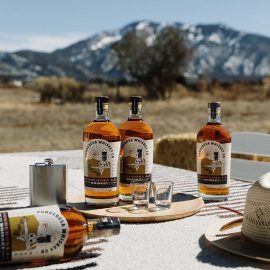NM Whiskey Ponderosa Whiskey bottles on table horizontal mountains credit Amanda Powell